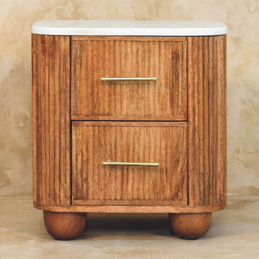Aurora marble top bedside table standing next to a bed