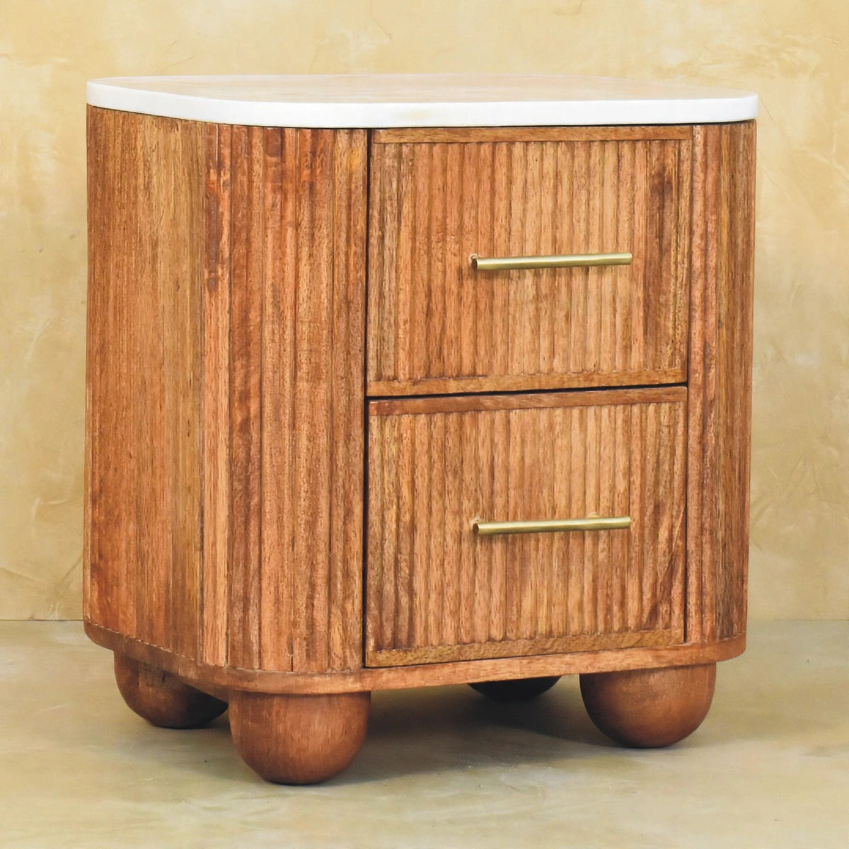 Brass drawer handles on the Aurora mango wood bedside table