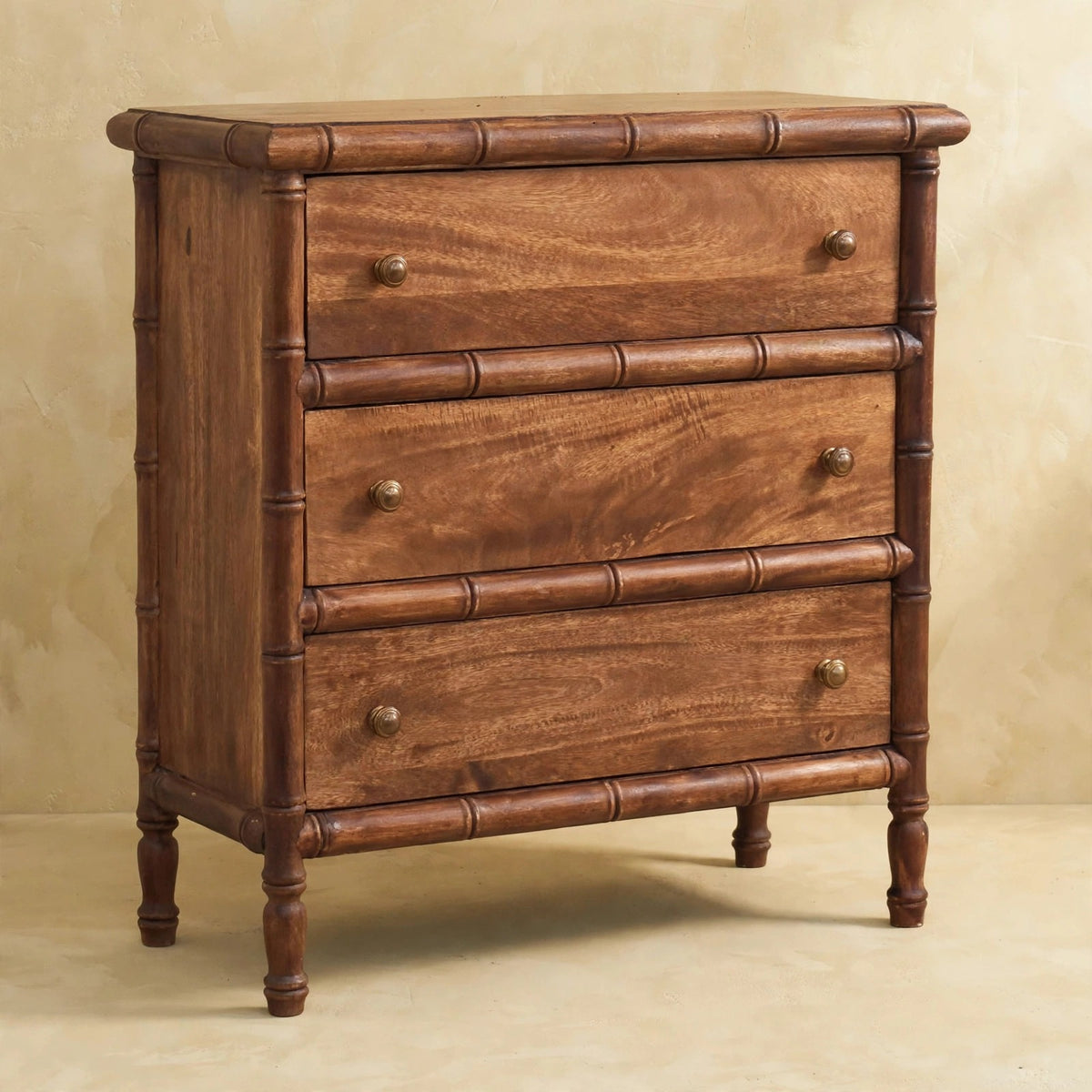 Three-drawer chest with bamboo-style carved framing and a roasted almond finish