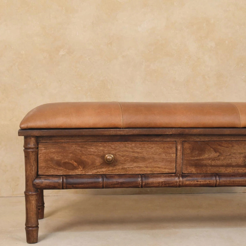 Mango wood bench with a mocha leather cushion and a lower shelf holding décor