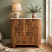 Four-drawer mango wood chest with a white marble top, styled in a bedroom