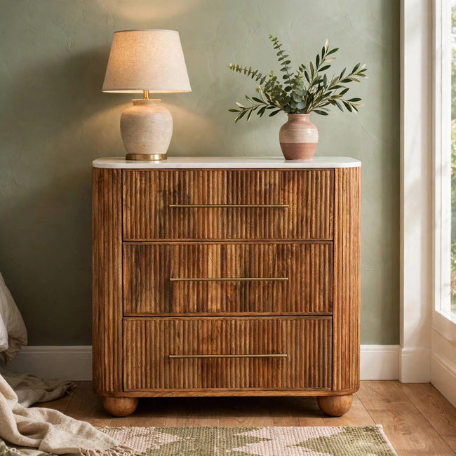 Four-drawer mango wood chest with a white marble top, styled in a bedroom