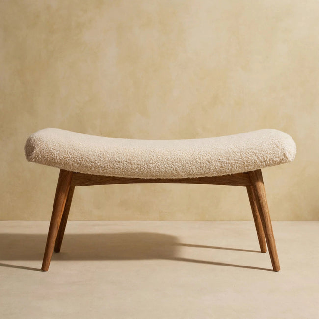 Front view of the curved cream boucle bench in a living space