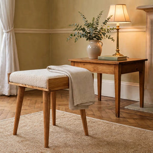 Cream boucle tray-style footstool with solid mango wood legs in a living room