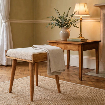 Cream boucle tray-style footstool with solid mango wood legs in a living room
