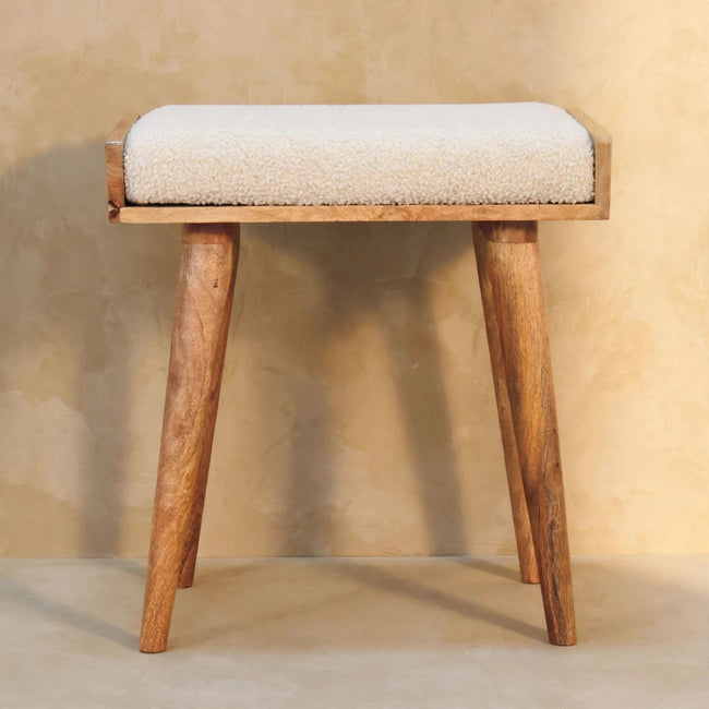 Side view of the cream boucle footstool showing its Nordic-style mango wood legs