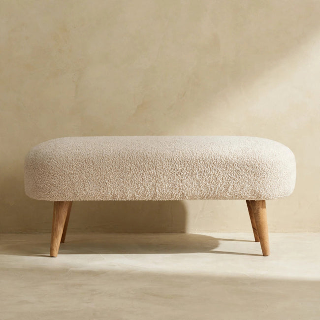 Side view of the cushioned bouclé bench seat in a styled hallway