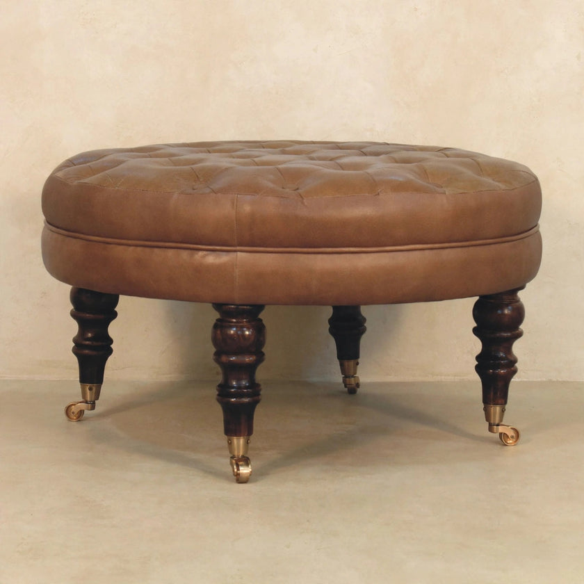 Close view of brown buffalo leather ottoman with deep button tufting in a styled interior