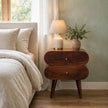 Bubble Chestnut bedside table with two round capsule-style drawers in a styled bedroom