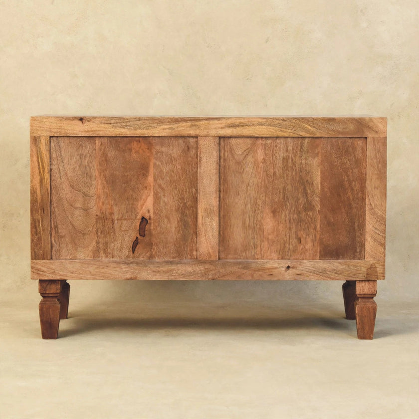 Shoe cabinet in a styled room showing the carved drawers and open shelf