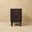 Carved shoe storage bench in a bedroom or dressing space setting