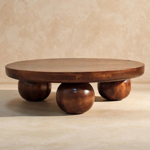 Low chestnut coffee table with ball feet styled in a room setting