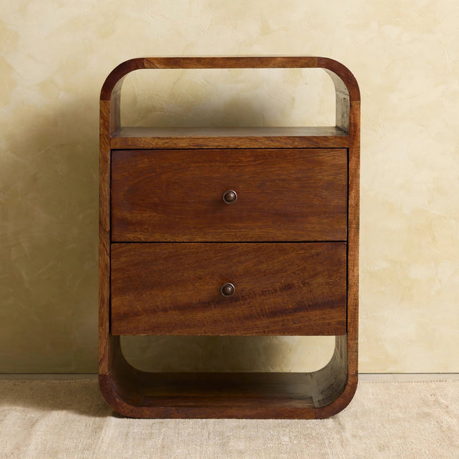 Chestnut finish bedside table with two drawers and brass knobs beside a bed