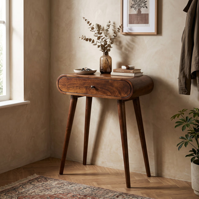 Mini chestnut mango wood console table with two drawers, shown in a room setting