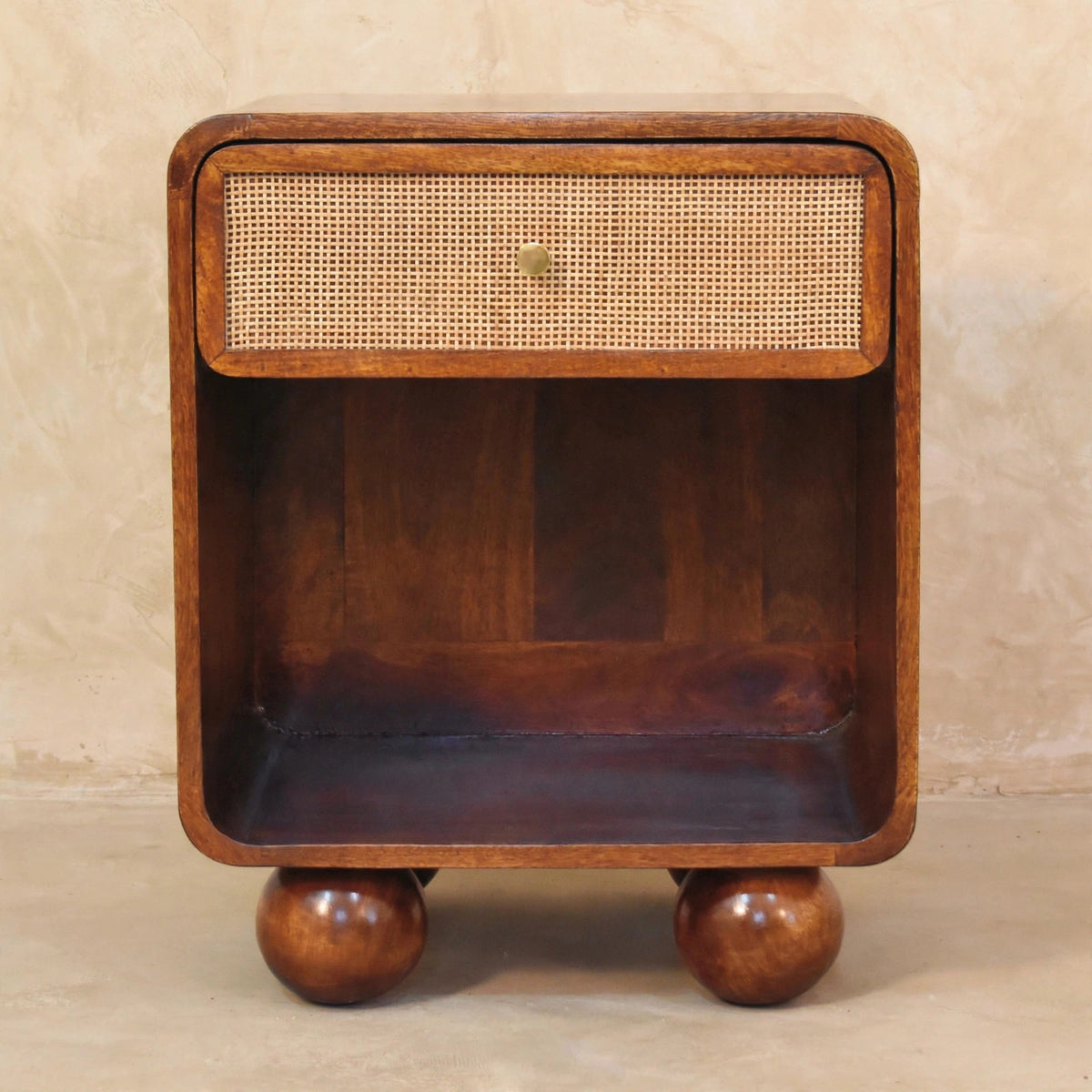 Woven-front bedside table with mango wood legs beside a bed