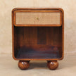 Woven-front bedside table with mango wood legs beside a bed