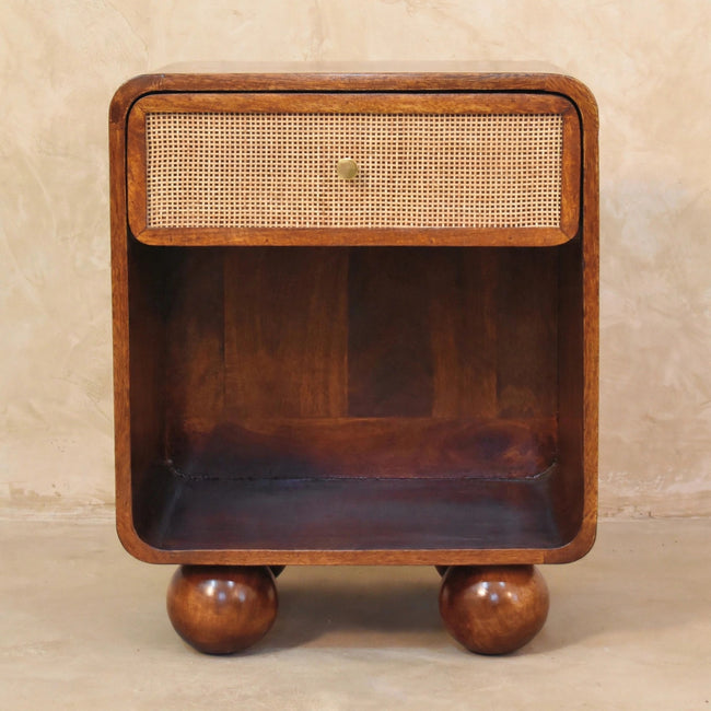 Woven-front bedside table with mango wood legs beside a bed