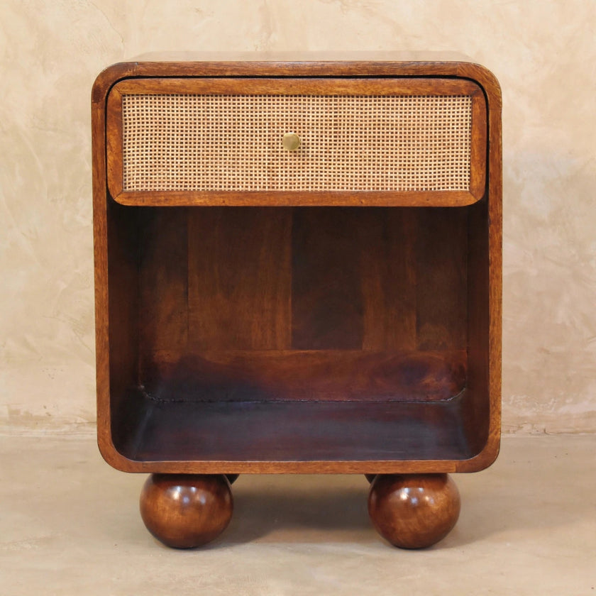 Woven-front bedside table with mango wood legs beside a bed