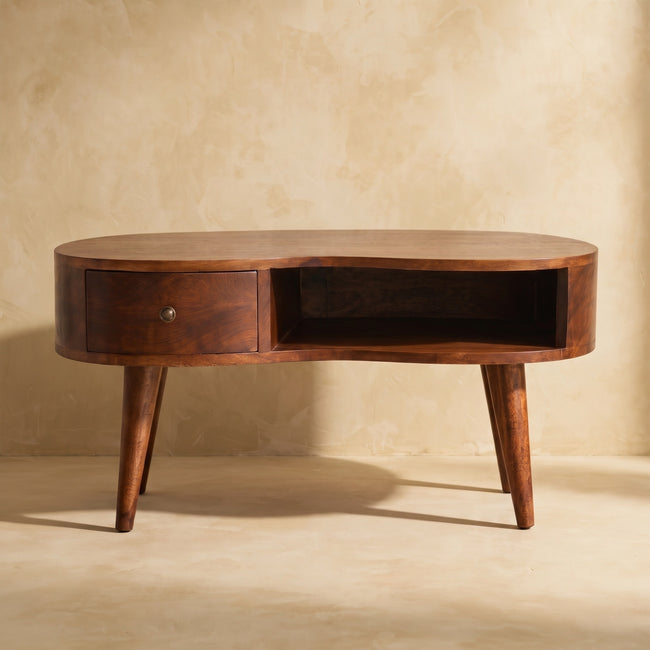 Chestnut-finish wave-shaped coffee table with rounded edges, seen from the side in a room