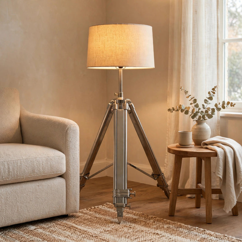 Chrome tripod lamp with a neutral lampshade styled in a room
