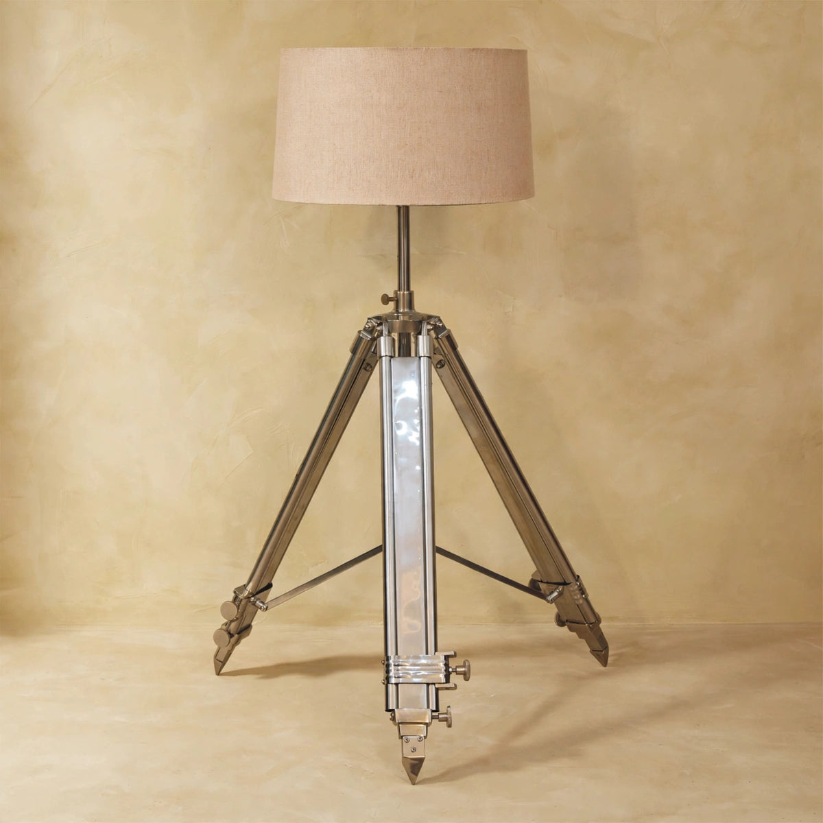 Chrome tripod base and neutral lampshade in a home interior