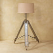 Chrome tripod base and neutral lampshade in a home interior