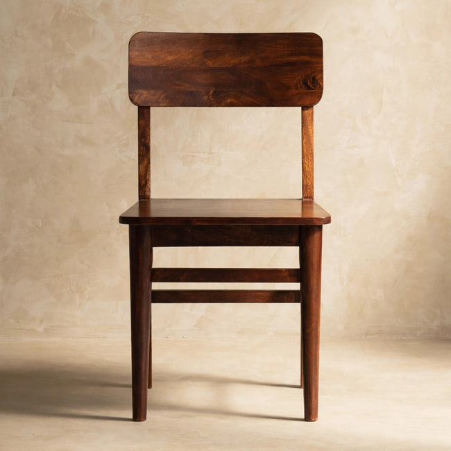 Front view of the chestnut-finish mango wood dining chair in a styled room