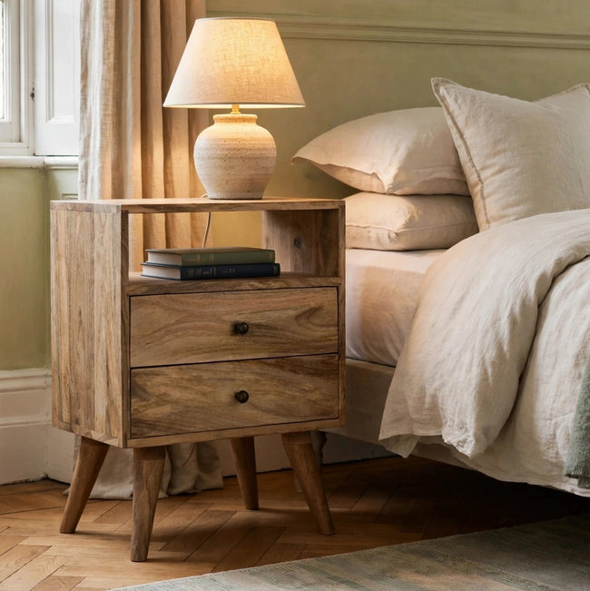 Solid mango wood bedside table with brass knobs in a bedroom setting