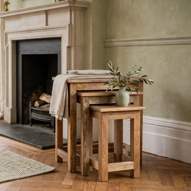 Set of 3 country solid mango wood stools with an oak-ish finish, shown in a room setting