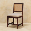Side view of the cream boucle chair showing the mango wood frame and rattan back