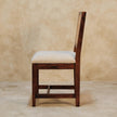 Close-up of the woven rattan back on the cream boucle accent chair