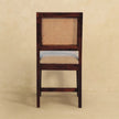 Cream boucle rattan chair seen at an angle, showing the seat and wood frame