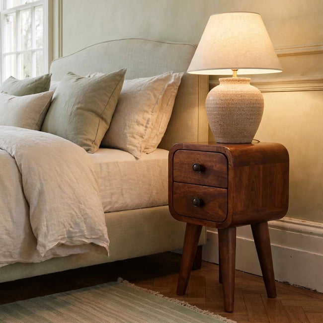 Extra mini curved chestnut bedside table with two drawers in a bedroom