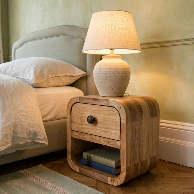 Extra mini curved mango wood bedside table with an open lower shelf in a bedroom