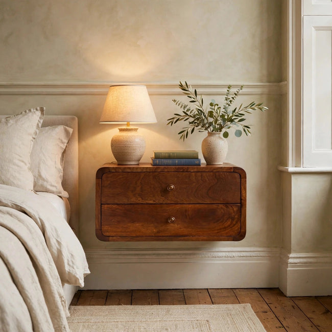 Curved floating bedside table in chestnut mango wood mounted on a bedroom wall