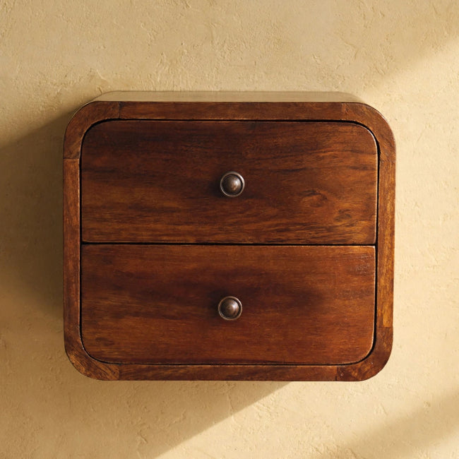 Wall-mounted solid mango wood bedside table with chestnut finish next to a bed