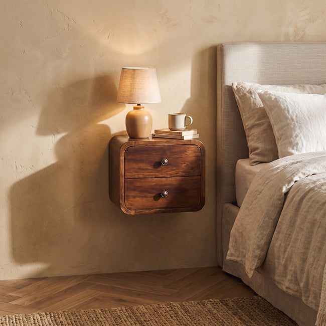 Floating mini chestnut bedside table with two drawers mounted on a bedroom wall
