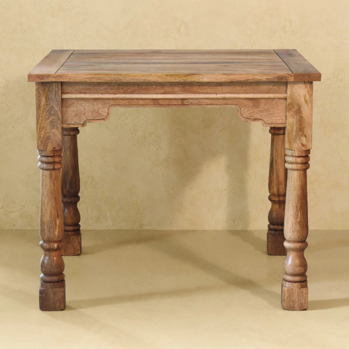 Side view of the mango wood dining table and ladder-back chairs