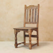Dining chair with a ladder back and turned front legs next to the table