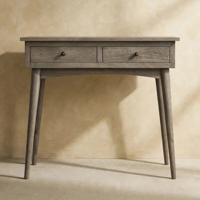 Console table with two drawers and shiny knobs styled against a hallway wall