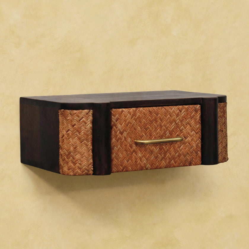 Floating mango wood bedside table with a brass handle next to a bed