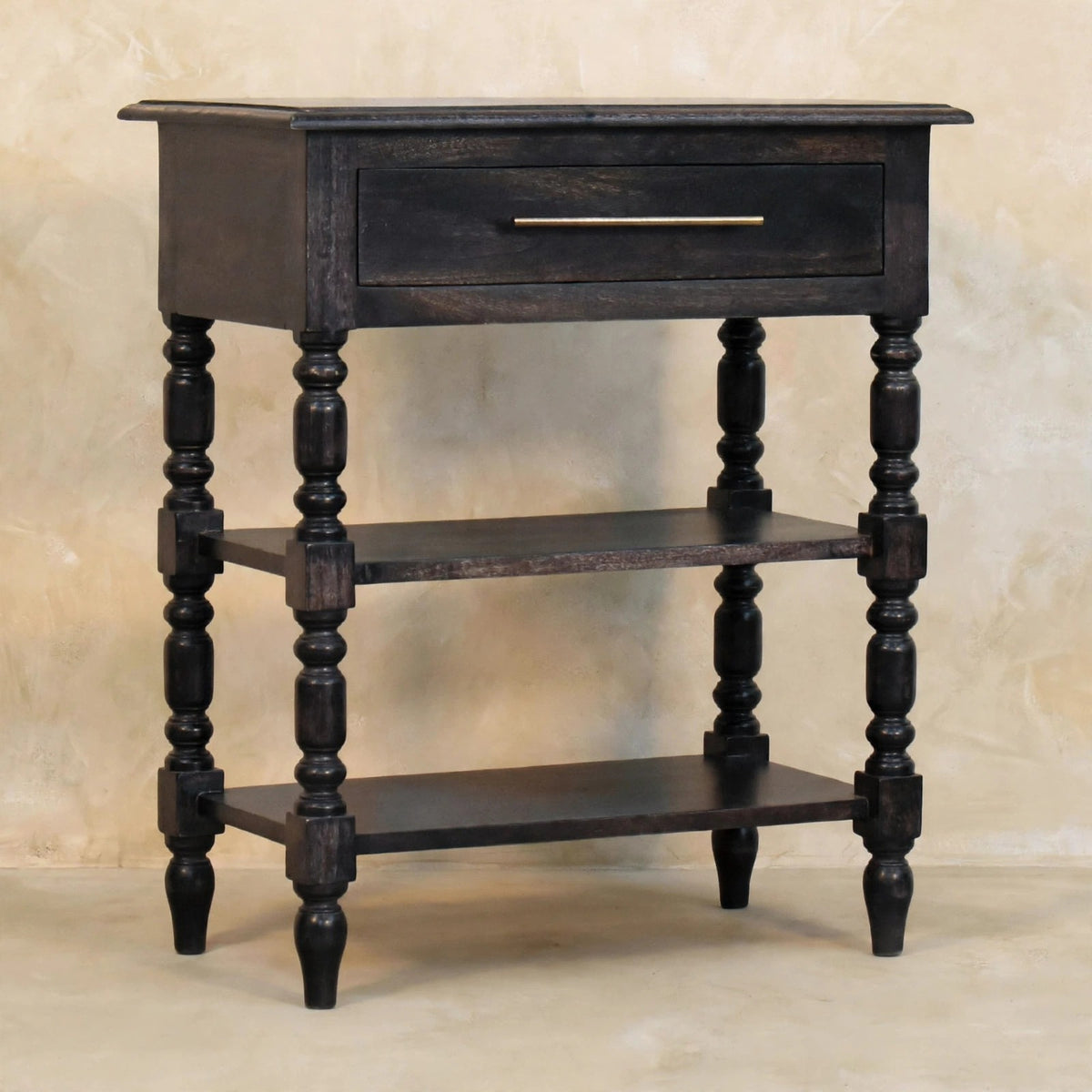 Side table in carbon ash finish styled with books and decor on the open shelves
