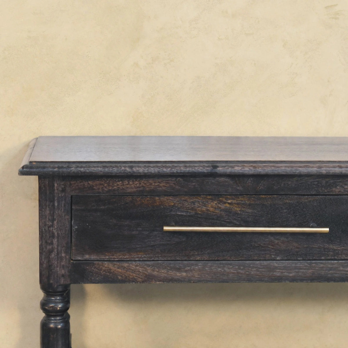 Front view of the side table showing the drawer with brass-finished handle