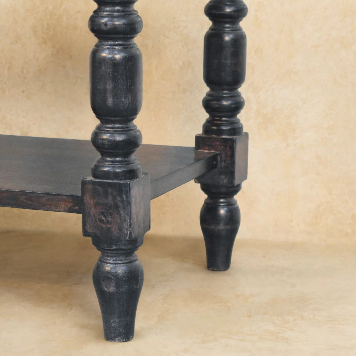 Side table with turned legs used as a hallway accent with a basket on the lower shelf