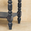 Side table with turned legs used as a hallway accent with a basket on the lower shelf
