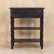 Turned-leg mango wood side table in a styled living room next to a sofa