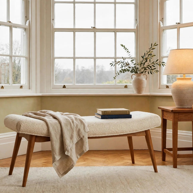 Cream boucle curved bench with honey caramel mango wood legs styled in a living space