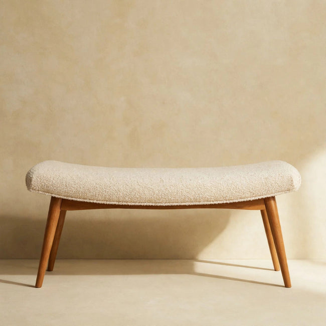 Curved cream boucle bench in a room, showing the soft textured seat and rounded shape