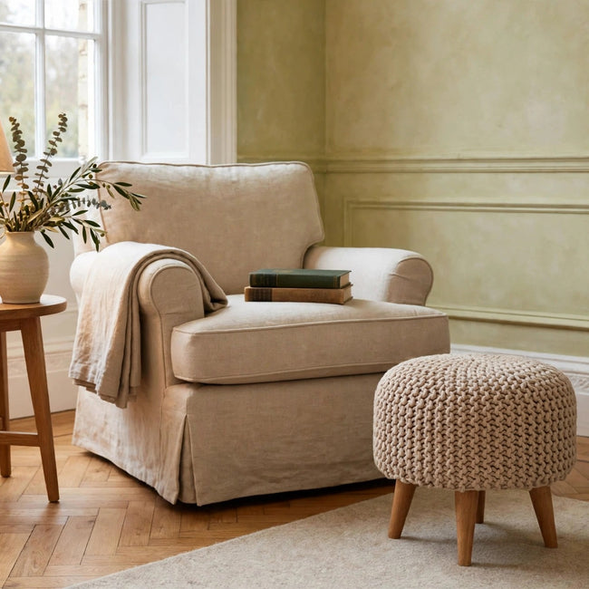 Keeva beige round footstool with woven top and oak-effect legs in a living room
