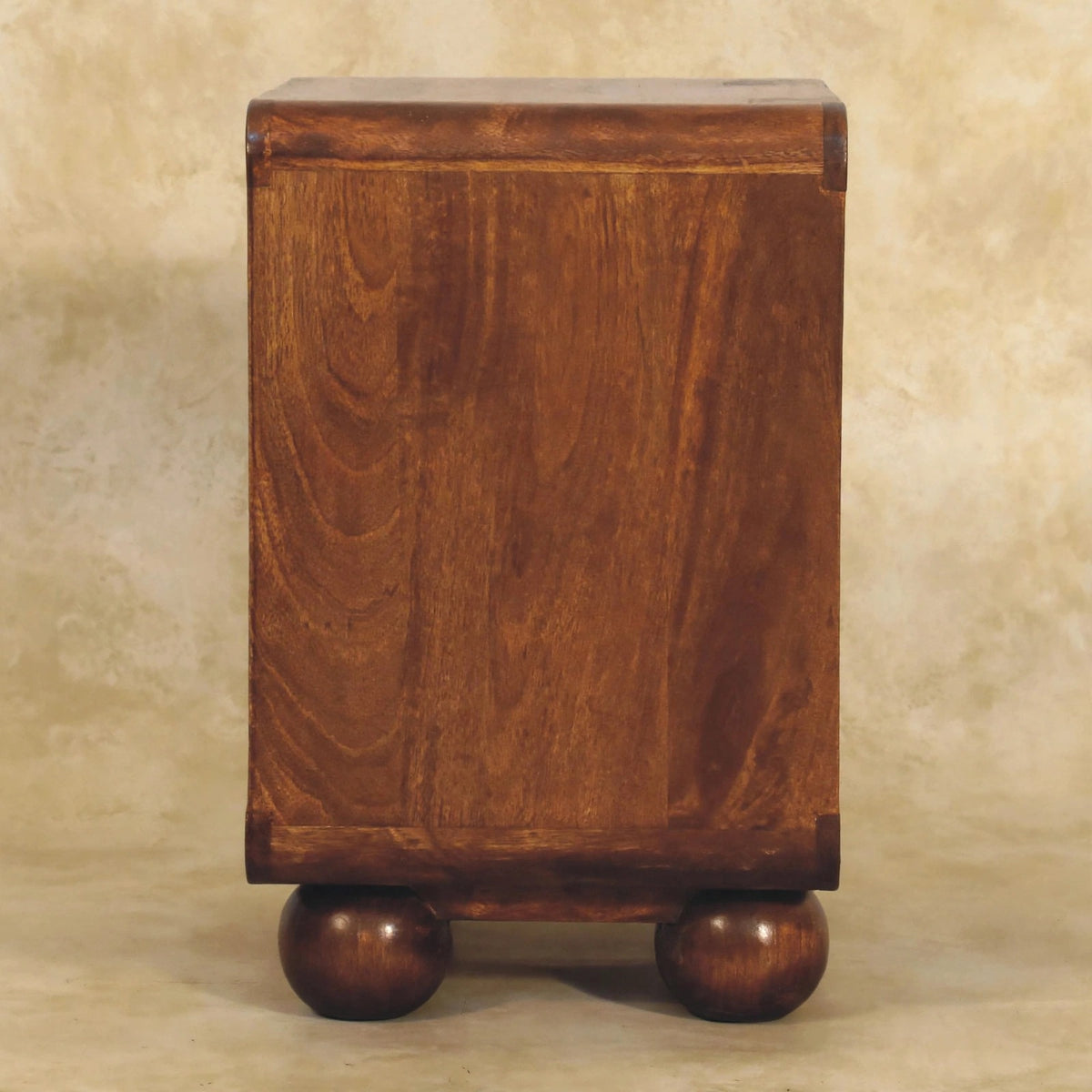 Chestnut 2 drawer nightstand next to a bed with a lamp and books on top